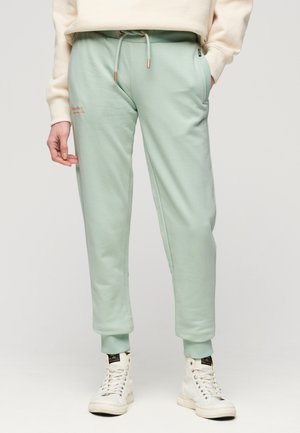 Pantalons de jogging vert menthe en tissu doux, avec des poignets élastiques, des poches latérales, une taille à cordon de serrage et un détail de logo brodé subtil.