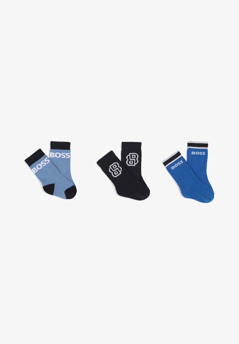 Trois paires de chaussettes : bleu clair avec le logo blanc "BOSS", noir avec le logo gris "B", et bleu foncé avec des rayures blanches et l'inscription "BOSS".