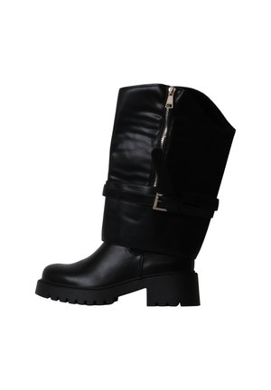 Botte en cuir noire mi-mollet avec talon épais, fermeture éclair latérale et bride décorative à boucle sur fond blanc.