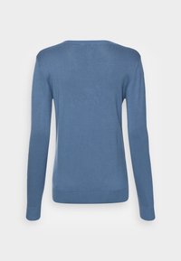 Blauwe gebreide trui met een ronde hals, lange mouwen en een gladde textuur. Heeft een aansluitend ontwerp met geribde manchetten en zoom.