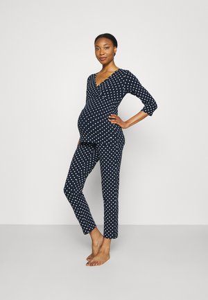 Ensemble de pyjama de maternité à pois navy comprenant un haut à col en v et des manches trois-quarts, avec un bas ajusté et un tissu doux et extensible.