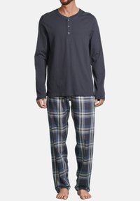 T-shirt henley à manches longues gris foncé avec trois boutons, associé à un pantalon de pyjama à carreaux bleus avec des accents blancs et gris clair.