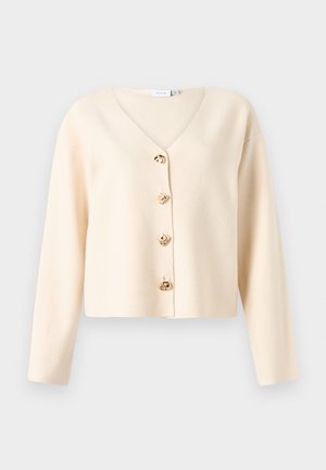 Kreemivärvi kardigan V-kaelusega, millel on ees viis kuldse tooniga nuppu ja pikad varrukad. Pehme ja sile tekstuur.