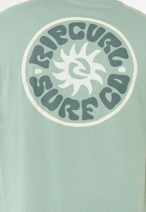 Lichtgroen T-shirt met een ronde crèmekleurige afbeelding met gestileerde tekst "RIPCURL SURF CO" en een zonontwerp aan de achterkant.