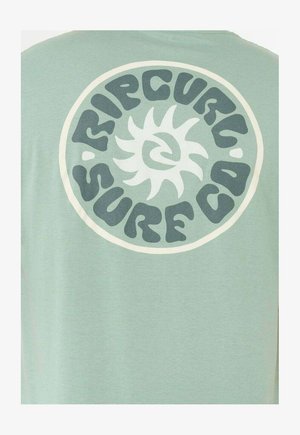 Lichtgroen T-shirt met een ronde crèmekleurige afbeelding met gestileerde tekst "RIPCURL SURF CO" en een zonontwerp aan de achterkant.