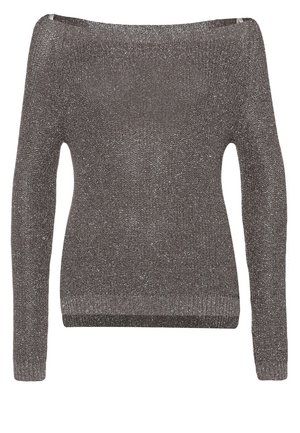 Femme portant un pull en maille gris, un jean skinny bleu, des bottines noires, tenant une pochette beige dans sa main gauche.