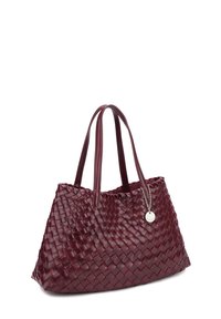Dunkelrote Lederhandtasche mit gewebtem Muster, zwei Schulterriemen und einem kleinen runden silbernen Anhänger, der an einer Kette befestigt ist.