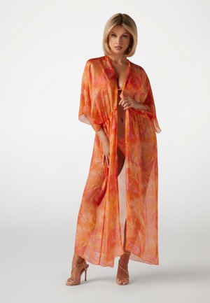 Lightweight, sheer orange kimono with a floral pattern. Open front design and wide sleeves, paired with strappy metallic heels.
