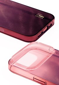 Custodia per telefono trasparente in sfumatura rosa con finitura scintillante. Presenta ritagli per pulsanti e fotocamera, e un logo inciso.