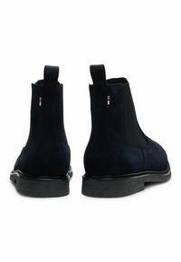 Granatowe zamszowe botki Chelsea z czarnymi elastycznymi panelami bocznymi, pętelkami do zakładania i fakturowanymi czarnymi gumowymi podeszwami. Gładki, elegancki design.