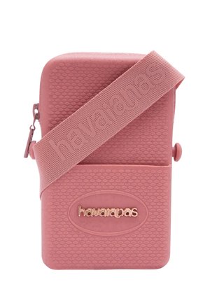 Bolso bandolera rosa texturizado con el logo en relieve "havaianas" y una correa ancha a juego que también presenta la marca "havaianas".