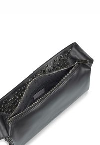 Borsetta in pelle nera con interno texturizzato caratterizzato da ritagli circolari. Chiusura con zip e hardware in metallo. Finitura esterna liscia.