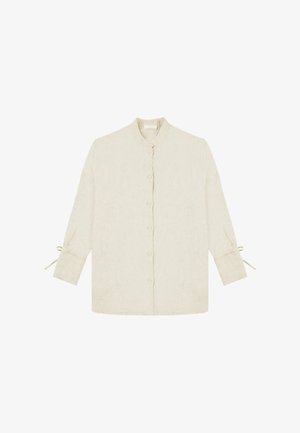 Button-up shirt in light beige linen with a stand collar, long sleeves, and tie accents at the cuffs. Textured, breathable fabric.