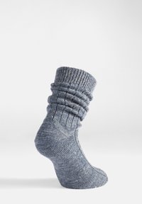 Calcetín gris de punto con un puño texturizado y acanalado y un diseño holgado. El material parece suave con un patrón jaspeado, mostrando un aspecto casual.