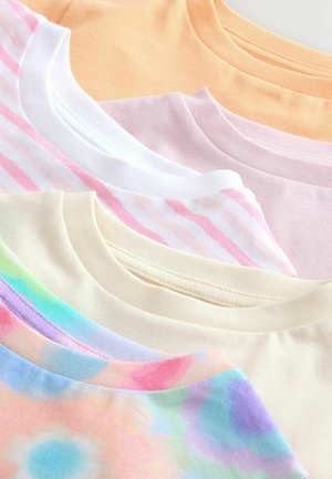 Cinq t-shirts disposés en ligne, présentant des couleurs variées : pêche, blanc avec des rayures roses, rose clair, crème, et un motif floral pastel multicolore.