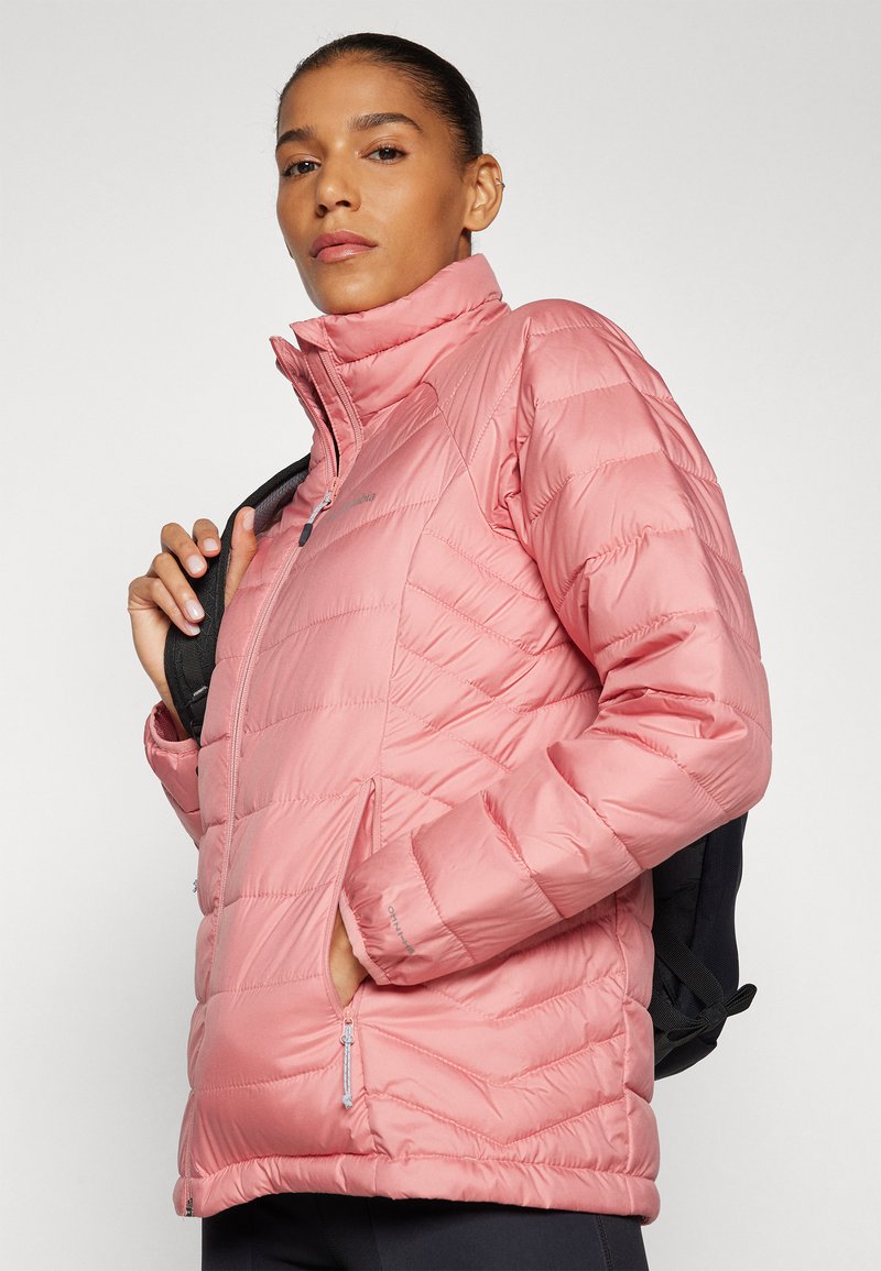 Giacca a vento rosa con colletto alto, caratterizzata da un design trapuntato, tasche con zip e una vestibilità slim. Il materiale sembra lucido e leggero.