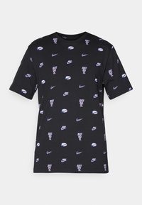 Camiseta negra de algodón con mangas cortas, que presenta un patrón repetido de logotipos de Nike y el texto "Just Do It" en púrpura y blanco.