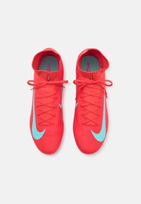 Red Nike Mercurial soccer cleats with blue accents, featuring a textured upper, sleek design, and traditional lace-up closure.