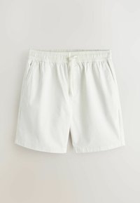Shorts blancs à taille élastique avec cordon de serrage et poches latérales, fabriqués en tissu léger.