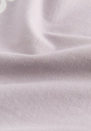 Lichtroze stof met een gladde, gestructureerde oppervlakte. Het materiaal is zacht en losjes gedrapeerd, wat de fijne weving en subtiele glans benadrukt.