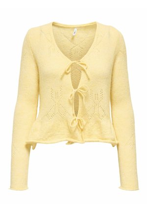 Žlutý pletený kardigan s výstřihem do V, zavazováním vpředu a dlouhými rukávy. Obsahuje krajkové vzory a volánový lem. Měkká textura.