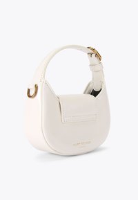 Borsa in pelle bianca con forma arrotondata, manico piccolo, chiusura a patta e dettagli in metallo oro. Presenta cuciture decorative e il nome del marchio.
