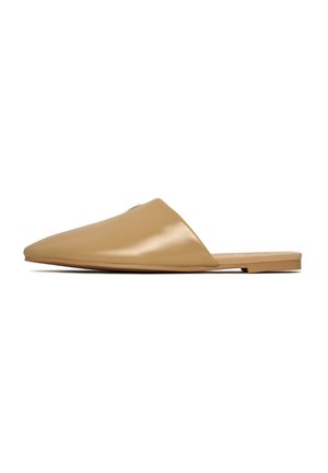 Zapatos slip-on de cuero color marrón claro con puntera puntiaguda y suela plana. Textura suave y hardware mínimo, con un diseño elegante.