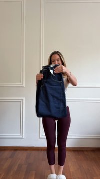 Dark blue denim jeans held up, featuring traditional five-pocket design, belt loops, and a price tag attached at the waist.