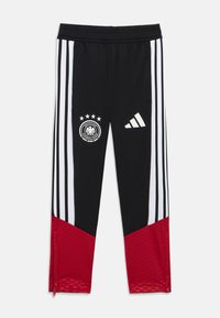 Schwarze Sporthose mit weißen Streifen, roten Akzenten, Logo des Deutschen Fußball-Bunds und Adidas-Emblem. Mit Reißverschlüssen am Knöchel.