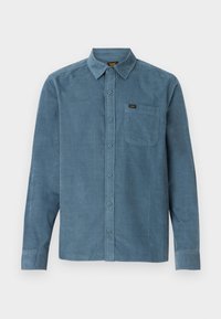 Long-sleeve shirt in blue corduroy, featuring a button-down collar, front pocket, and subtle branding on the pocket.