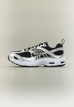 Chaussure de running Nike noire et argent avec semelle blanche, dessus en mesh, logo Swoosh latéral, lacets noirs et languette au talon, vue de profil.