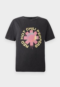 Black cotton t-shirt featuring a central colorful graphic of a star logo with "HOT CHILI PEPPERS" in bold yellow text around it.