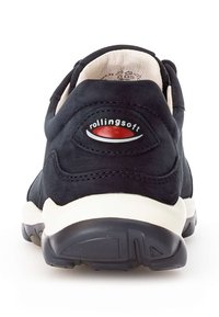Scarpa in suede nero con tacco imbottito e zeppa bianca. Presenta un logo circolare rosso e bianco "rollingsoft" sul retro. Suola in gomma testurizzata.