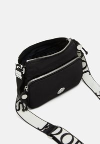 Borsa a tracolla nera in nylon con due scomparti con zip, hardware argentato e una tracolla regolabile con un motivo a logo bianco.