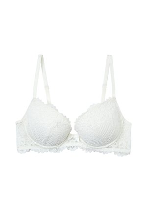 Witte kanten beha met padded cups, geschulpte randen en verstelbare bandjes. Heeft een kleine strikdetail in het midden en een textuur met bloemenpatroon.