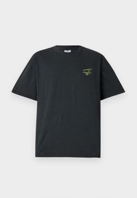 T-shirt en coton noir à manches courtes, avec un petit détail graphique vert sur la poitrine, col rond et coupe décontractée.