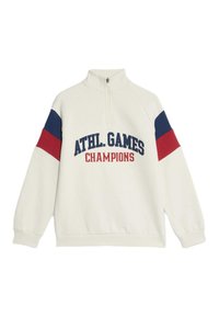 Sudadera crema con media cremallera, con paneles en los hombros azules y rojos y "ATHL. GAMES CHAMPIONS" impreso en azul marino y rojo.