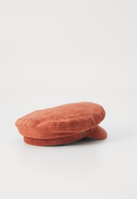 Terracotta baret gemaakt van zacht, textuurgegeven stof. Heeft een ronde kroon en een kleine zijrand. Gedetailleerde stiksels zichtbaar aan de rand.