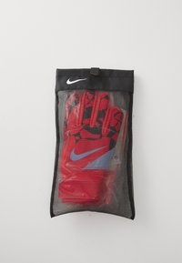 Sarkani Nike cimdi ar melnu ģeometrisku rakstu, ar zilu akcentu. Iepakoti caurspīdīgā sietā maisiņā ar melnu augšdaļu un logo.