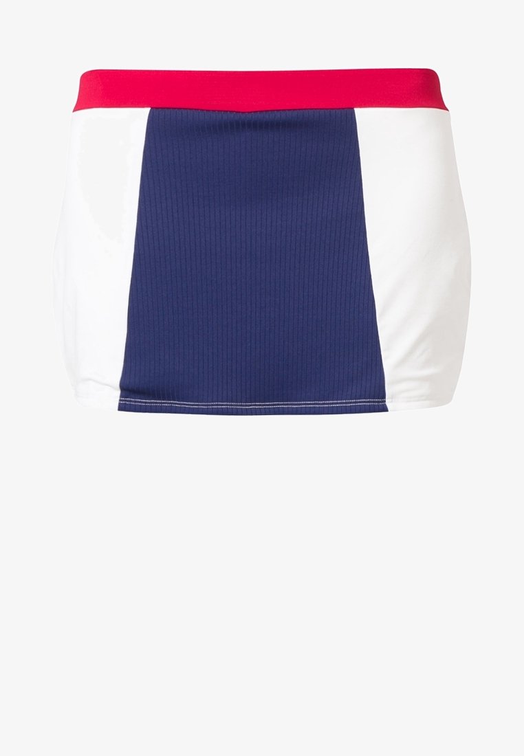 Falda azul marino con textura acanalada, que presenta paneles laterales blancos y una cinturilla roja. El diseño es deportivo y ceñido.