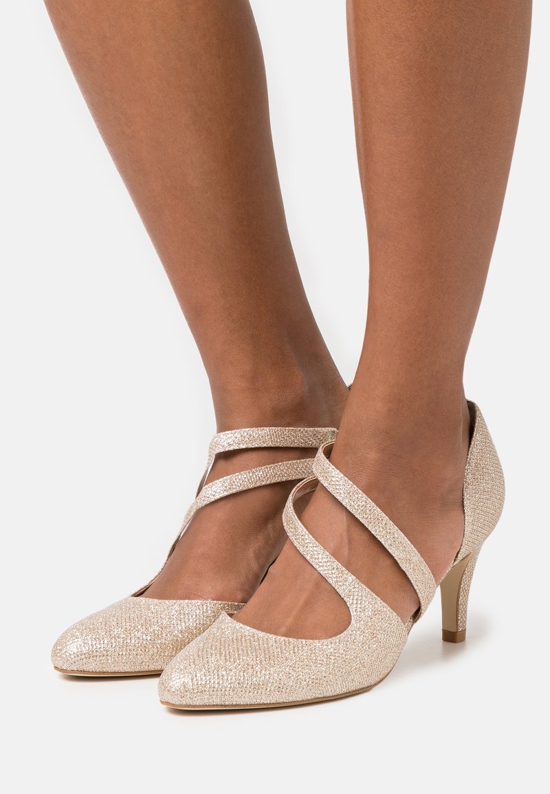 Escarpins pailletés dorés avec bout pointu et brides à la cheville. Dotés d'un talon fin et d'une surface texturée pour un détail visuel.