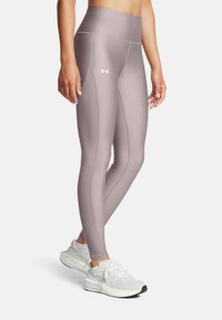 Ljust lila sportleggings med hög midja, med texturerade sidopaneler och dekorativ sömnad, i kombination med vita sneakers.