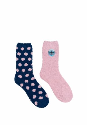 Un calzino blu navy con pois rosa e un calzino rosa con una piccola toppa raffigurante un personaggio dei cartoni animati blu. Entrambi sono soffici.