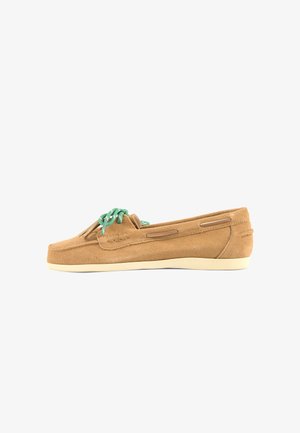Bruine suède loafer met groene veters en crèmekleurige zool, zijaanzicht op een witte achtergrond.