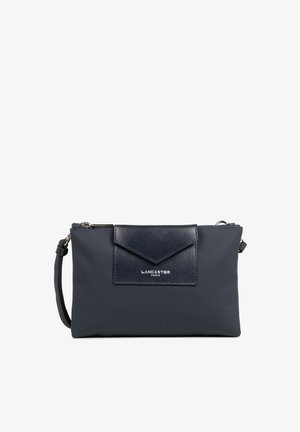 Borsa a mano blu navy con corpo testurizzato e patta in pelle liscia. Presenta hardware in argento e una tracolla rimovibile. Logo visibile sul fronte.