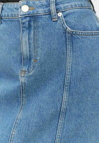 Högmidjad blå denimkjol med en framficka, kontrasterande sömmar och knäppning, som visar en klassisk A-linjeform.