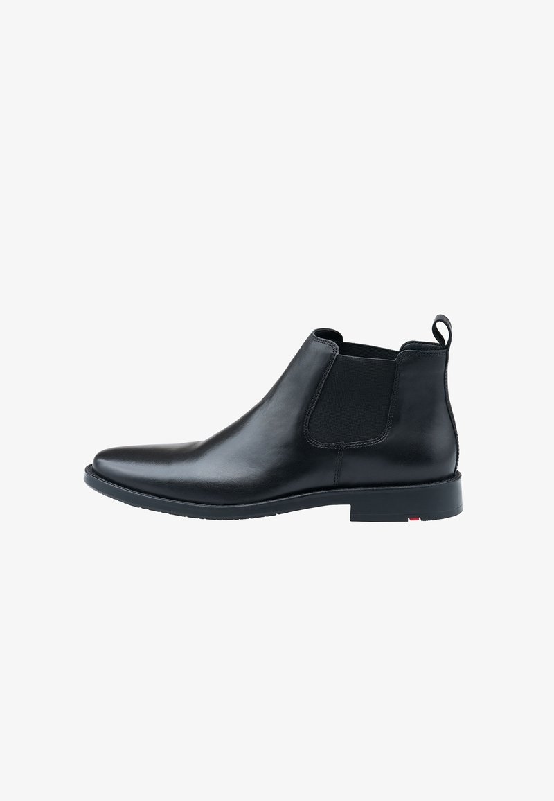 Botte Chelsea en cuir noir avec panneaux latéraux en élasthanne, surface lisse, bout arrondi et petit talon carré. Présente une languette à l'arrière.