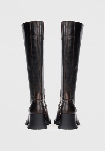 Barnak, térdig érő bőrcsizma sima textúrával, enyhén szélesedő fekete sarokkal és hangsúlyos varrással az oldalak mentén.