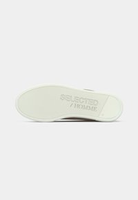 Hvit skosåle med teksturert grep og "SELECTED / HOMME" merke, størrelse 45, vist mot en enkel hvit bakgrunn.