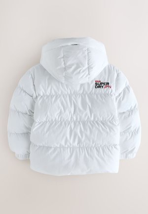 Chaqueta blanca de plumón con capucha, con secciones acolchadas. Texto en negro y rojo "SUPER DRY JPN" en la parte superior de la espalda. Textura lisa y brillante.